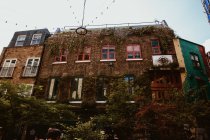 LONDRA, REGNO UNITO - 23 OTTOBRE 2018: Dal basso foto della facciata muschiata dell'antico edificio in mattoni sulla strada di Londra, Inghilterra — Foto stock