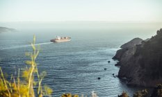 Bateau naviguant sur la mer près des rochers du rivage par temps ensoleillé à San Francisco, États-Unis — Photo de stock