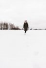 Donna che salta tra il campo di neve — Foto stock