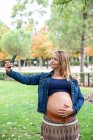 Femme enceinte attrayante en utilisant le téléphone mobile — Photo de stock