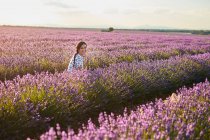 Jovem mulher sentada entre campo de lavanda violeta — Fotografia de Stock