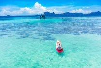 Rückenansicht männliche Bootsfahrt auf Kanu mit Paddel auf atemberaubendem azurblauem Meer und blauem Himmel in Malaysia — Stockfoto