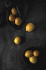 Limoni freschi maturi sparsi su sfondo scuro — Foto stock
