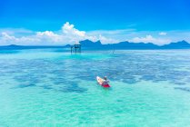 Paseos en canoa con remo en el increíble mar azul y el cielo azul en Malasia - foto de stock
