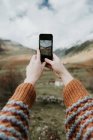 Mãos de colheita de senhora com telefone celular fotografar vista pitoresca do vale com montanhas maravilhosas e céu nublado em Pirinéus — Fotografia de Stock