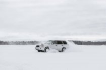 Auto fährt auf Schneefeld — Stockfoto