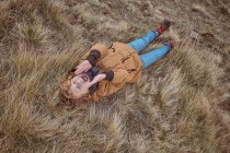 Дитина лежить на сухій траві біля струмка — стокове фото