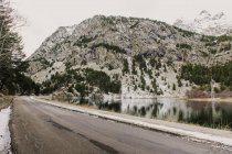 Verschneite Strecke zwischen Bergen und einem See in den Pyrenäen — Stockfoto