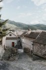Panoramic view of ancient town near high hills with forest and blue sky with clouds in Pyrenees — Stock Photo