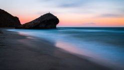 Размахивая морем и скалистой скалой во время удивительного заката на природе — стоковое фото