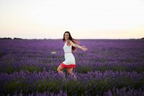 Молодая женщина бежит между фиолетовым лавандовым полем — стоковое фото