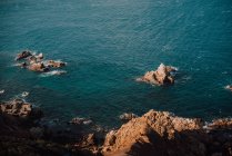 Costa rocosa y aguas azules tranquilas - foto de stock