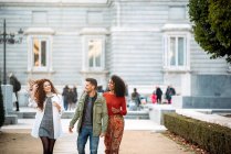 Três jovens amigos caminhando e bebendo café nas ruas de Madrid no inverno — Fotografia de Stock