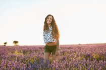 Jovem mulher sorrindo entre campo de lavanda violeta — Fotografia de Stock