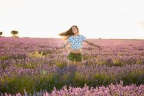 Усміхнена молода жінка крутився у великому Фіолетове поле лаванди — стокове фото