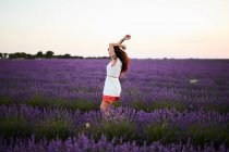 Jeune femme entre champ de lavande violette — Photo de stock