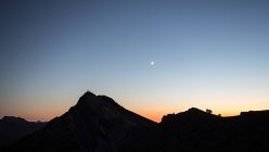 Вечірнє небо над пагорбом і горами — стокове фото