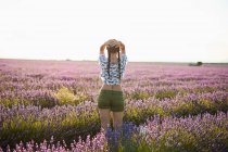 Giovane donna in piedi nel campo viola lavanda — Foto stock