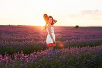 Young woman between violet lavender field in backlit at sunset — Stock Photo