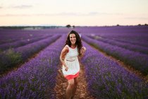 Junge Frau läuft zwischen violettem Lavendelfeld — Stockfoto