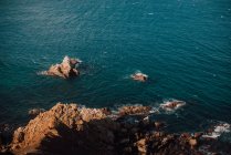 Côte rocheuse et eau de mer bleue calme — Photo de stock