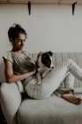 Menina adolescente com filhote de cachorro bonito no sofá — Fotografia de Stock