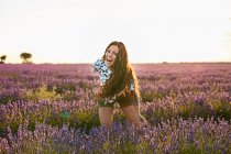 Jeune femme rieuse entre champ de lavande violette — Photo de stock