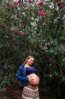 Усміхнена вагітна приваблива жінка в парку — стокове фото