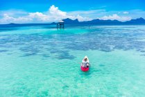 Back view male boating on canoe with paddle on amazing azure sea and blue sky in Malaysia — Stock Photo
