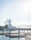 Маяк возле набережной моря в солнечную погоду — стоковое фото