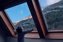 Junge blickt durch Fenster auf den Berg — Stockfoto