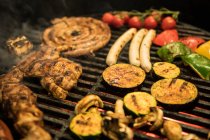 Nahaufnahme Scheiben mit verschiedenen Gemüsesorten und Fleisch auf heißem Grill braten — Stockfoto