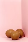 Œufs de poulet bruns crus sur fond rose — Photo de stock