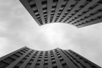 Снизу снимок великолепного современного здания необычной формы против пасмурного неба — стоковое фото