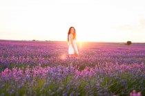 Jeune femme souriante entre champ de lavande violette — Photo de stock