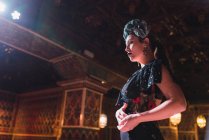 Молодая женщина в платье танцует фламенко на сцене в роскошной восточной комнате, украшенной мозаикой — стоковое фото