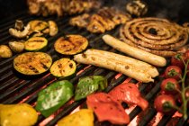 Крупный план ломтики разнообразных овощей и мяса жарки на горячем гриле — стоковое фото
