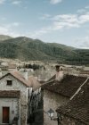 Vista panorámica de la antigua ciudad cerca de altas colinas con bosque y cielo azul con nubes en los Pirineos - foto de stock