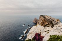 Rough cliff near sea on overcast day — Stock Photo