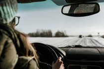 Mulher dirigindo carro no campo de neve — Fotografia de Stock