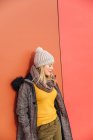 Blonde girl leaning on a colorful wall — Stock Photo