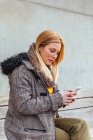 Porträt einer blonden Frau, die ihr Handy auf der Straße benutzt — Stockfoto