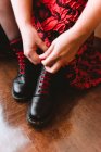 Woman in dress lacing boots — Stock Photo
