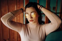 Trendy attractive charming woman in pink sweater with hands on head in room — Stock Photo