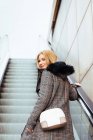 Ragazza bionda arrampicata scale mobili al centro commerciale — Foto stock