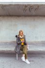 Porträt einer blonden Frau, die ihr Handy auf der Straße benutzt — Stockfoto