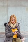 Retrato de mulher loira usando seu telefone celular na rua — Fotografia de Stock
