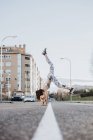 Woman doing handstand on street — Stock Photo