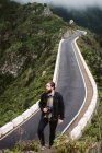 Fotógrafo barbudo olhando para longe na estrada da montanha — Fotografia de Stock