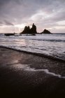 Самотня скеля в морі в похмурий день — стокове фото